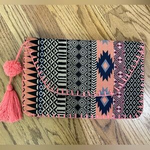 Aztec-y patterned clutch with pink tassel